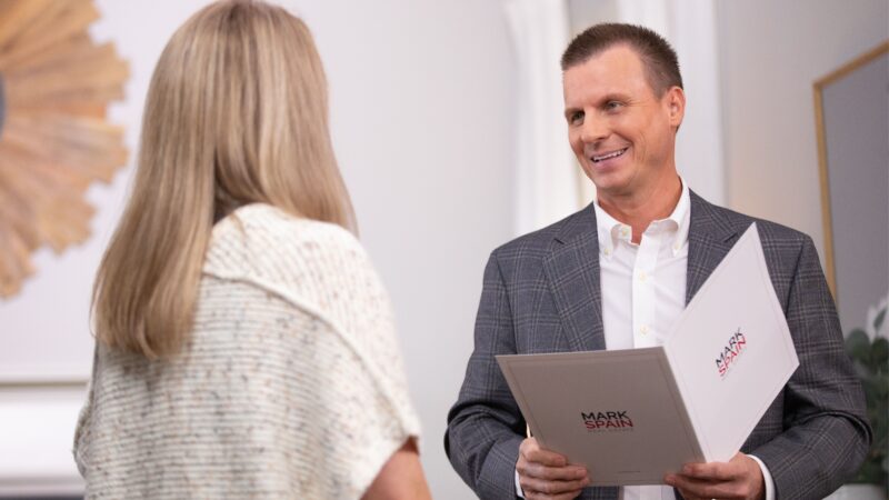 Mark Spain and agent talking about self-improvement at a meeting